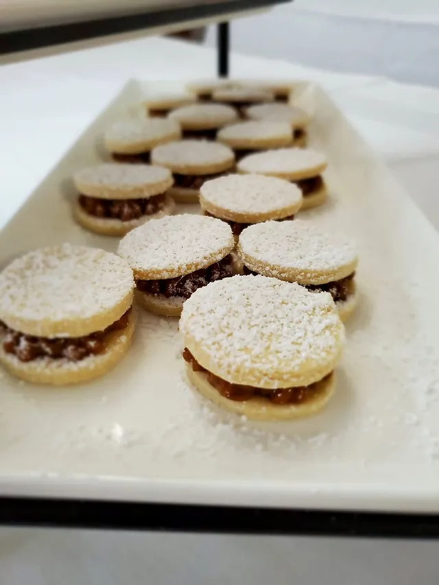 Rows of fresh alfajores lined up on a long platter