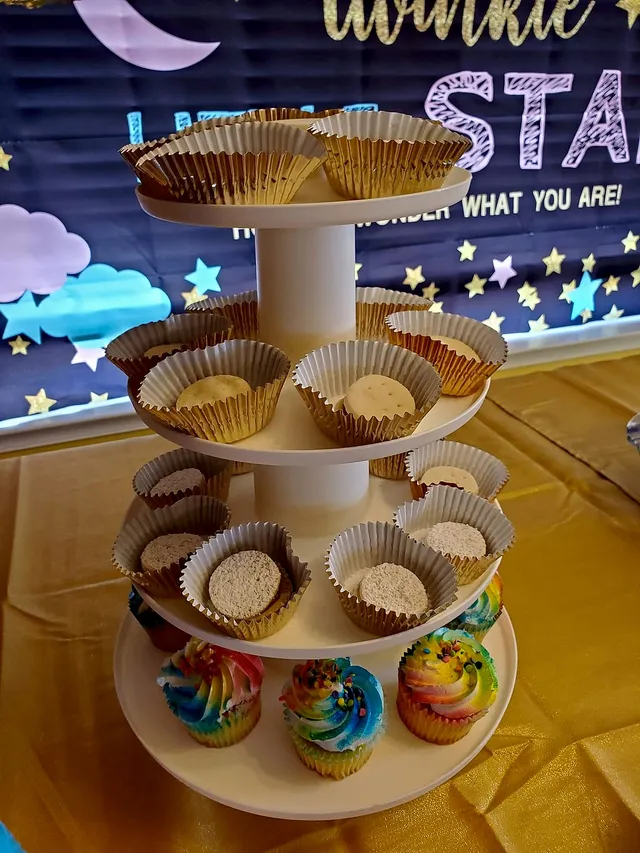 Tiered tower of alfajores and rainbow-frosted cupcakes