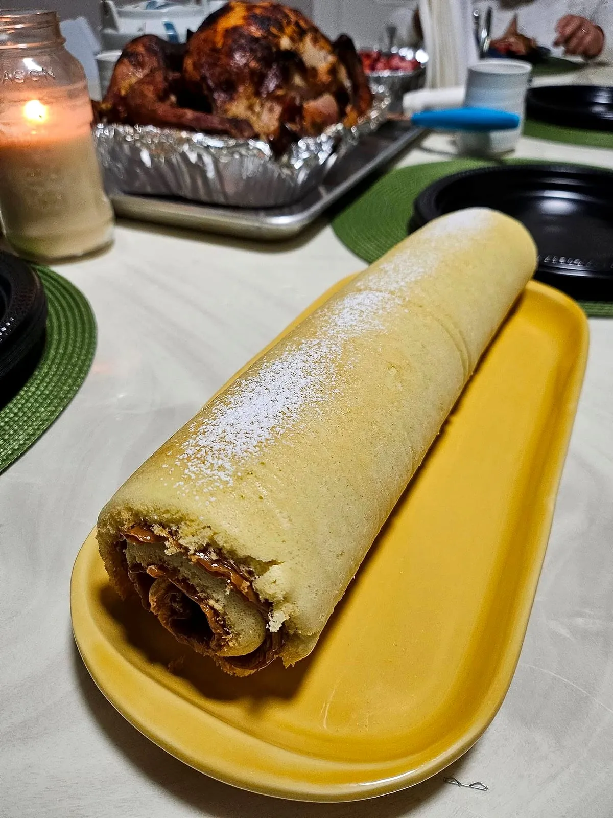 Pionono dusted with powdered sugar at the table